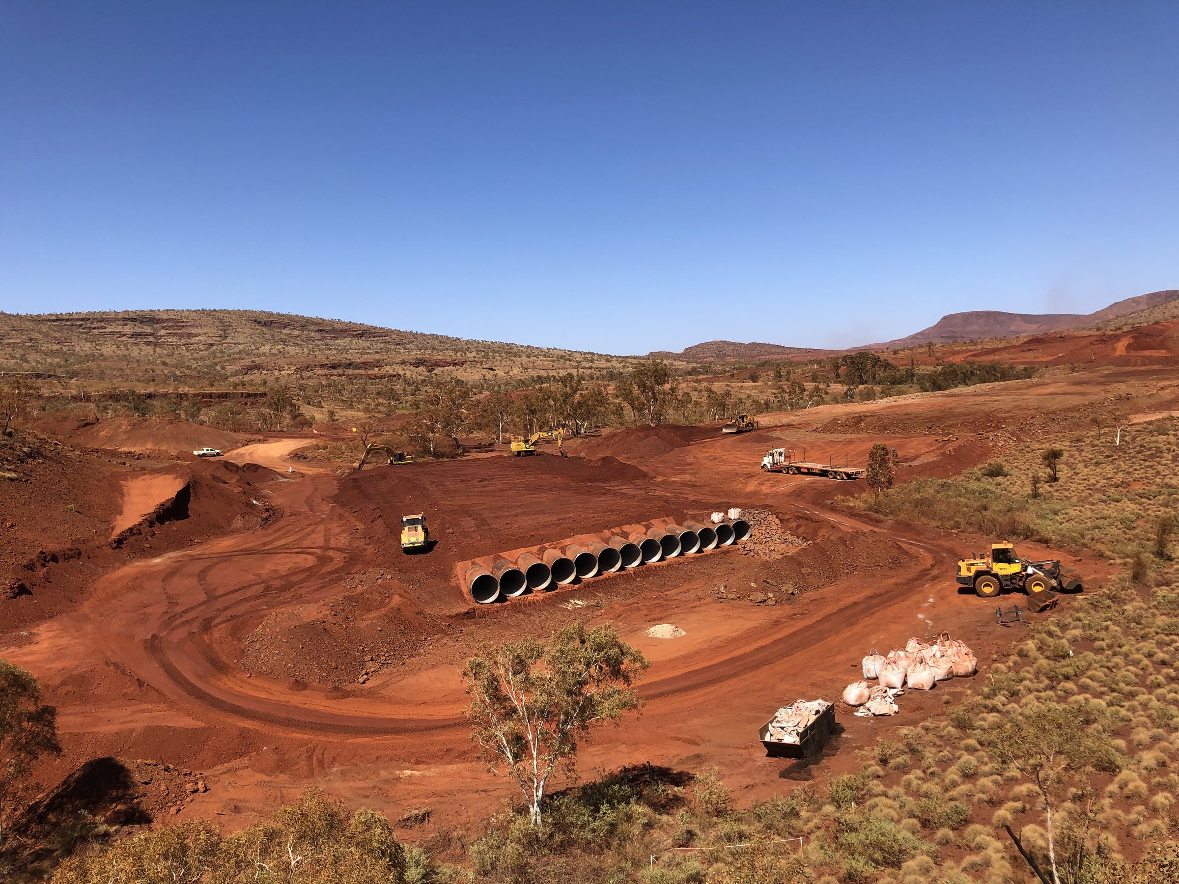 Bulk earthworks with culvert pipes staged on site, from above