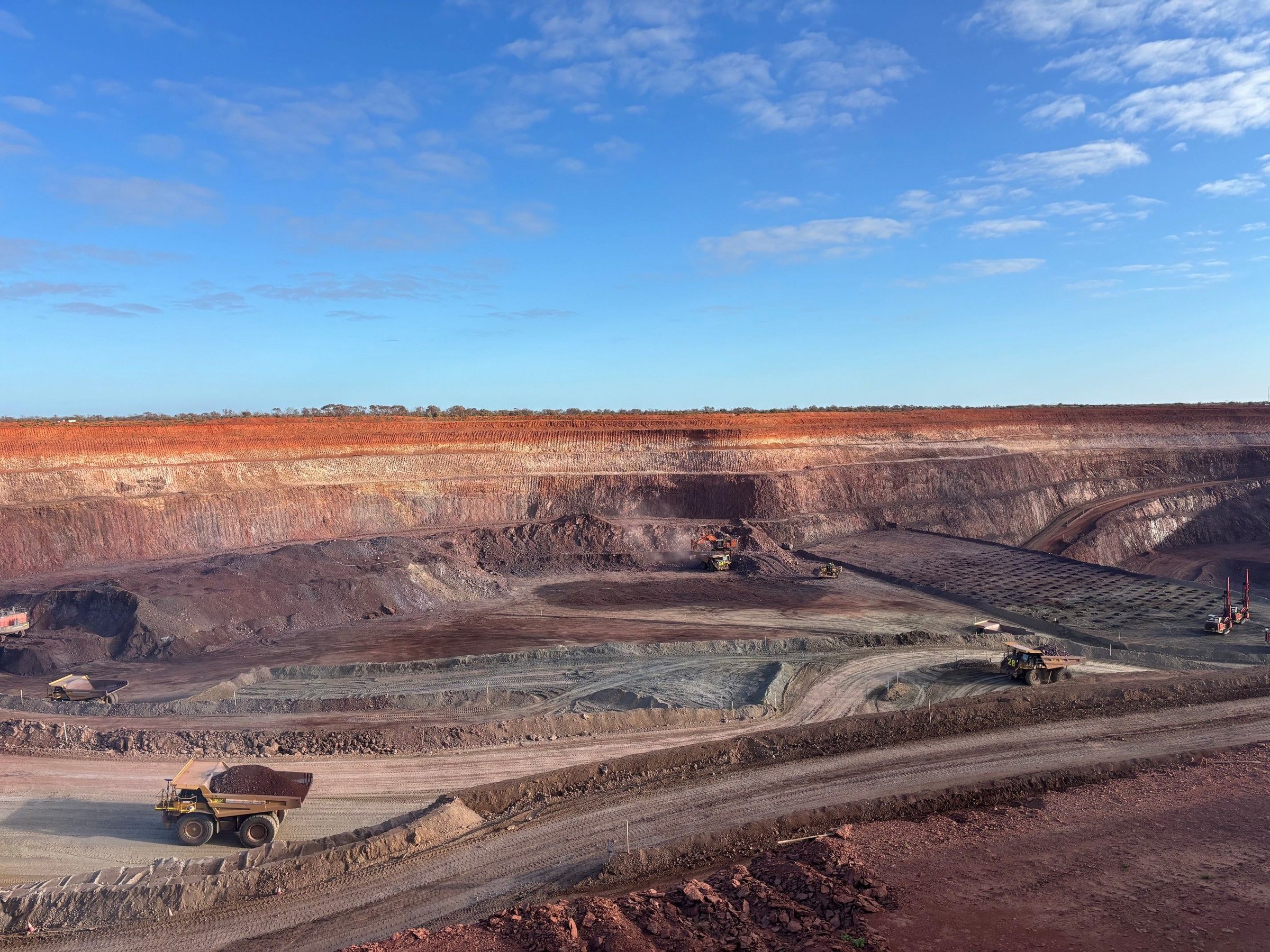 Haul trucks working the benches of an open cut pit