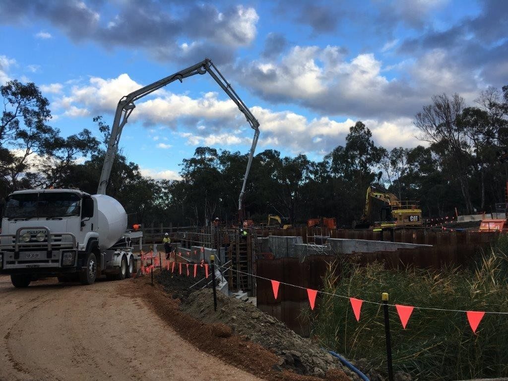 Concrete pump pouring a structure beside a waterway